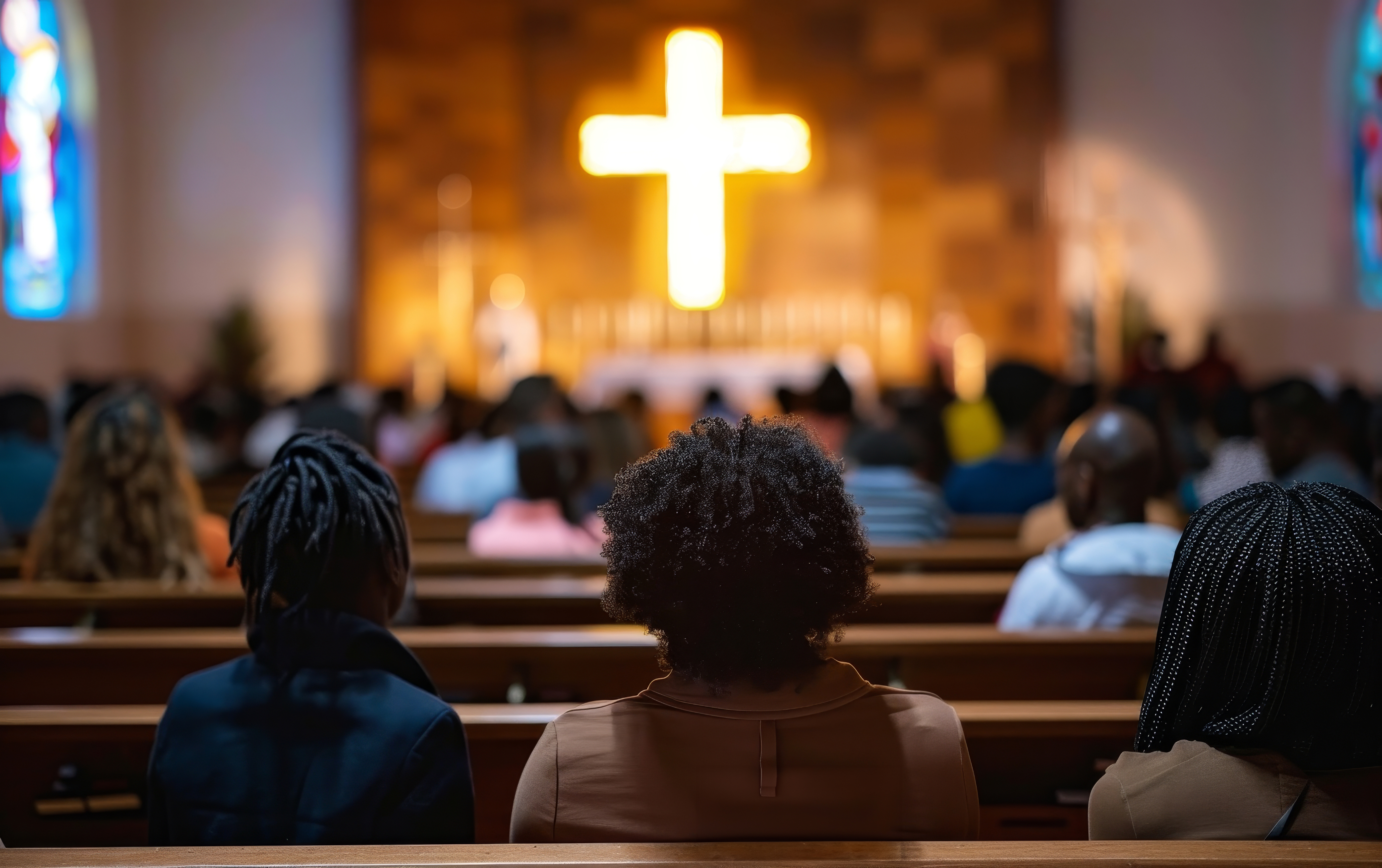 Traditional church congregation facing golden cross